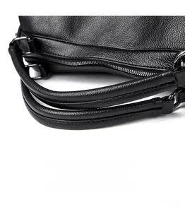 Macro detail of high-quality black leather handle with gunmetal hardware on handbag