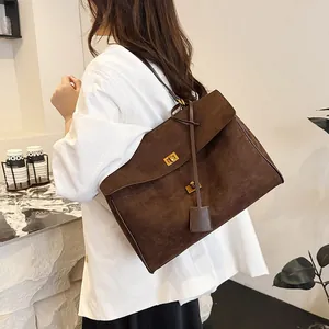 Détail du grand sac cabas en cuir mat marron foncé avec fermoir rotatif métallique