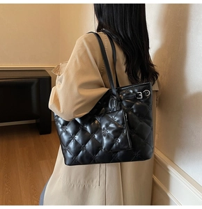 Détail d'un sac cabas noir matelassé avec broderie florale et sa mini pochette