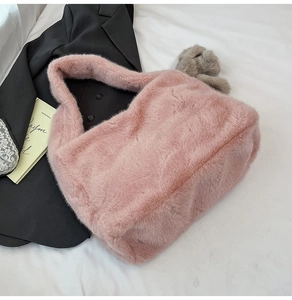 Detail of pink faux fur plush handbag texture with soft integrated wide handle