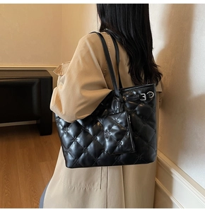 Détail du sac cabas matelassé noir avec gaufrage floral et pochette assortie