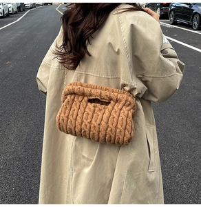 Close-up of brown knit shoulder bag with chunky cable texture and gold chain strap
