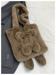 Detail of a brown plush tote bag featuring a cute 3D teddy bear design and soft texture