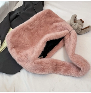 Pink faux fur tote bag detail featuring zipper closure and cute gray doll pendant