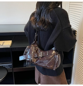 Gros plan d'un sac cabas vintage en cuir marron brillant avec détails zippés punk Y2K