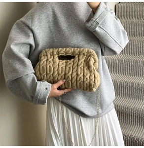 Detail of chunky cable-knit crossbody bag in beige with a slim gold metal chain strap