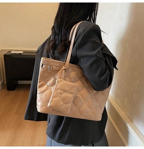 Détail du sac cabas en cuir matelassé avec pochette assortie et motif élégant en losanges