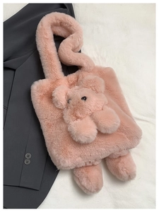 Close-up of pink plush shoulder bag featuring a cute 3D teddy bear and soft faux fur texture