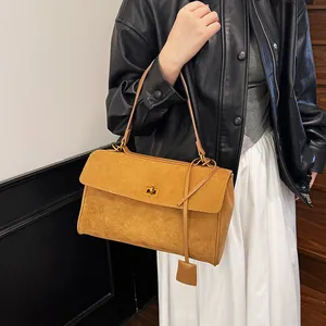 Détail du sac fourre-tout en daim camel avec fermoir doré et longues anses en cuir souple