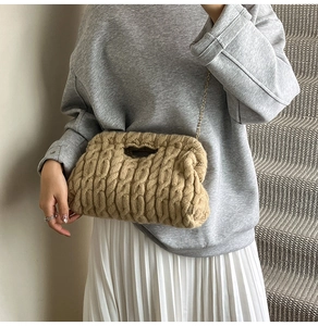 Detail of chunky knit shoulder bag with gold chain strap and textured diamond pattern