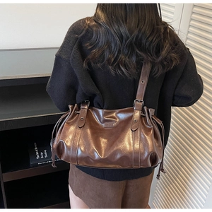 Détail d'un grand sac cabas en cuir PU marron brillant avec cordons de serrage
