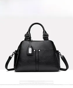 Detail of black pebbled leather Boston bag with silver studs and dual handles