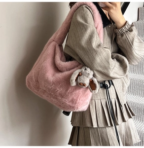 Detail of pink plush hobo bag featuring a soft faux fur strap and cute rabbit pendant