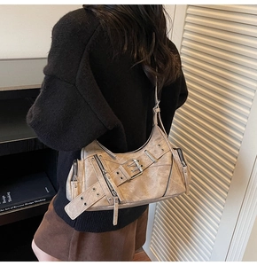 Détail du sac bandoulière vintage kaki avec boucles punk et texture lavée