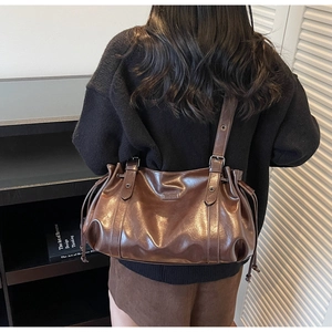 Détail macro du sac à bandoulière rétro marron foncé avec texture brillante et cordon