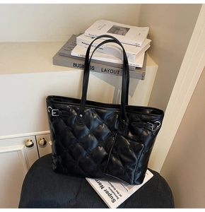 Détail d'un sac cabas noir matelassé avec pochette assortie en décor intérieur