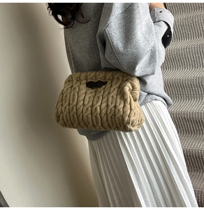 Detailed close-up of khaki knitted shoulder bag featuring textured cable knit pattern and gold chain