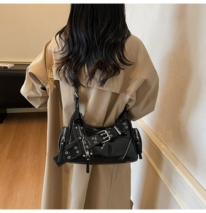 Détails d'un sac baguette en cuir verni noir avec boucles et accessoires métalliques