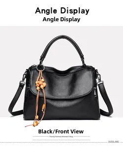 Detail of black lychee grain leather handbag with round metal handle and wood bead charm