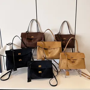 Détail de sacs cabas rétro en daim avec fermoirs dorés et bandoulières amovibles