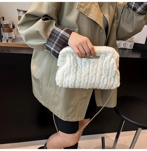 Detail of cream knit shoulder bag showing thick woven texture and gold chain strap