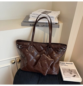 Détail du cabas matelassé marron avec broderies florales et mini pochette assortie