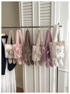 Assorted plush teddy bear tote bags displayed in multiple colors on a metal hanger