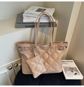 Détail d'un sac cabas beige matelassé avec pochette assortie au style urbain épuré
