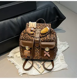 Detail of leopard print backpack with plush teddy bear patches and metal buckles