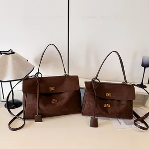 Comparaison détaillée de sacs cabas en daim marron en deux tailles avec boucles dorées