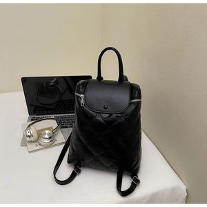 Detailed view of black quilted diamond pattern backpack with matte leather texture
