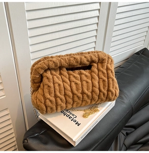 Detail of caramel chunky knit texture and gold chain on the quilted shoulder bag