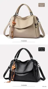 Detail view of lychee leather texture and wooden bead tassel on dual-color handbags