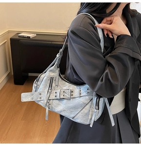 Détail d'un sac moto vintage avec texture denim délavée et fermetures éclair fonctionnelles