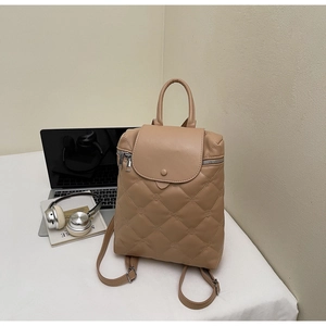 Close-up of beige quilted leather backpack with diamond stitching and silver hardware