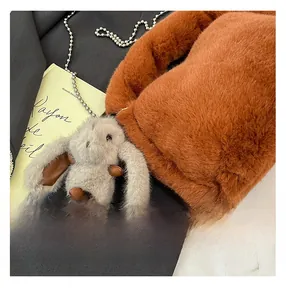 Detail of caramel plush bag featuring cute grey rabbit charm and silver beaded chain strap