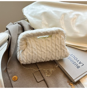Close-up of white chunky knit texture on handbag with a fine gold chain strap detail