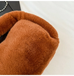 Gros plan sur la texture en fausse fourrure marron et la chaîne en métal argenté du sac