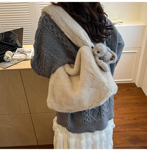 Close-up of fluffy plush shoulder bag texture with a cute grey rabbit charm detail