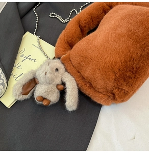 Vue détaillée du sac en peluche orange avec chaîne argentée et breloque lapin mignon