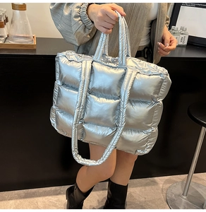 Detailed view of silver metallic quilted tote bag with padded texture and shoulder straps