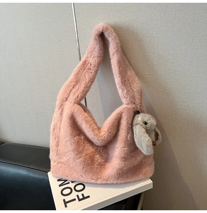 Detail of pink faux fur tote bag with plush rabbit pendant and wide shoulder strap
