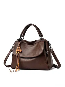 Detail of brown litchi pattern leather bag featuring a wood bead tassel charm