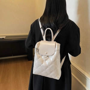 Fashionable beige quilted backpack with elegant floral embroidery and wavy flap cover