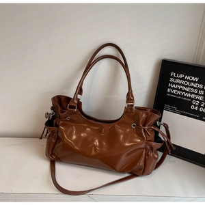 Detail view of large brown PU tote bag with drawstring texture and silver hardware