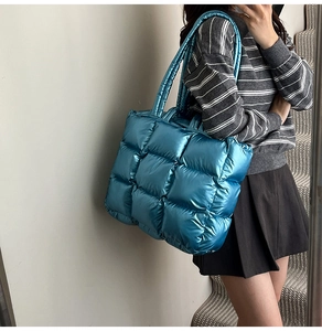 Close-up of metallic blue quilted tote bag made of high-gloss nylon fabric