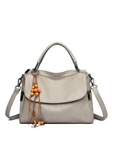 Close-up of grey litchi grain leather texture and decorative orange wood bead tassel