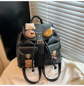 Detail showing plush food patches and gold metal locks on a black leather backpack