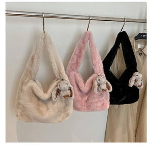 Close-up of soft faux fur shoulder bags in beige, pink, and black with cute bunny charms