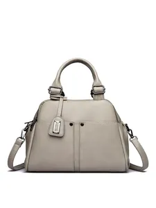 Macro shot of taupe pebbled leather Boston bag with stitching and rivet details